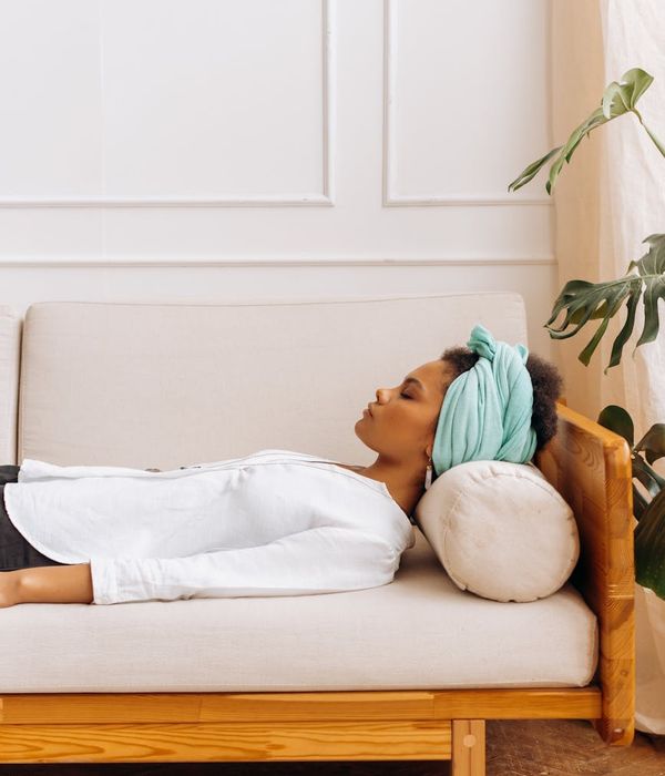 Woman in a peaceful yoga pose in a softly lit room.